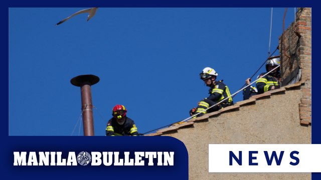 Vatican firefighters install a chimney on the roof of the Sistine Chapel for the papal election