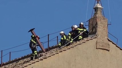 Los bomberos instalan la chimenea en el techo de la Capilla Sixtina del Vaticano