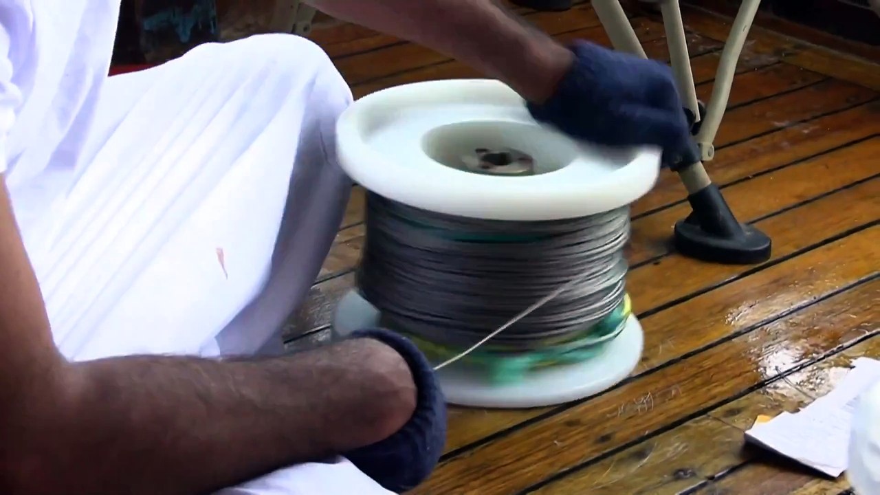 On the Doha seashore, rows of wooden dhow boats line a pier, with scores of fish on display