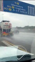 Un taré dans un caddie est accroché à un camion sur l'autoroute