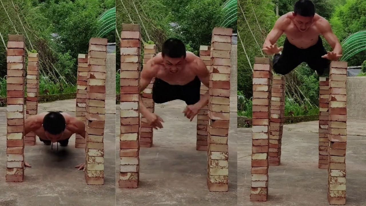 Mann hält Brett, indem er in beeindruckendem Stunt auf vier 1,47 Meter hohen Ziegelsteintürmen balanciert