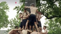 Gli studenti dell'Accademia Navale USA scalano il monumento ingrassato nella tradizione annuale