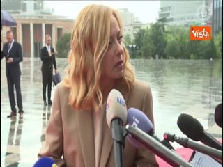 Meloni a Tirana sotto la pioggia ringrazia un cronista per aver aperto un ombrello al punto stampa