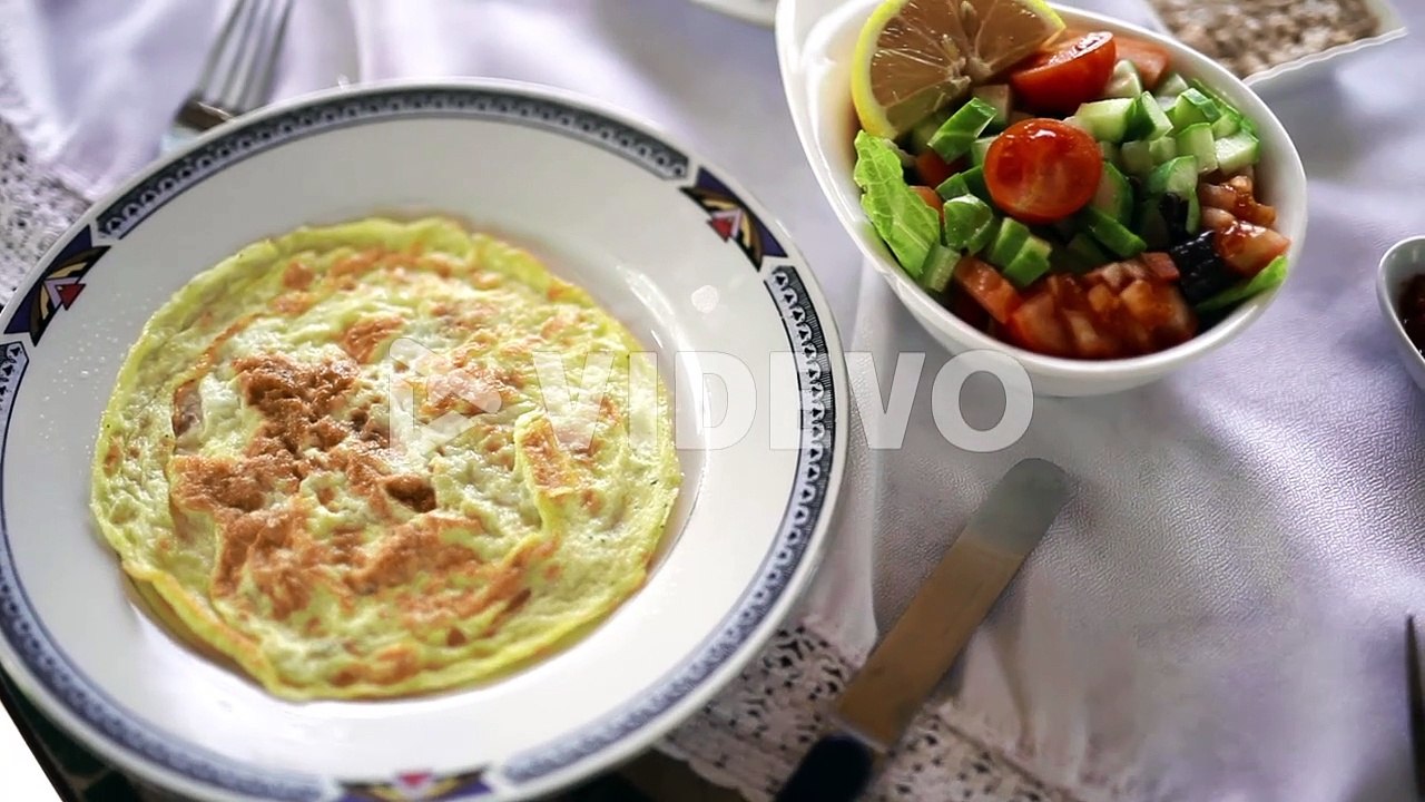 Thick fluffy omelette with green fruits salad hotel food
