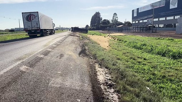 Semirreboque tomba na BR-277 em Cascavel e carga de farelo fica espalhada às margens da rodovia