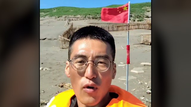 Un homme débarque par bateau sur une plage de Taïwan pour y planter un drapeau chinois