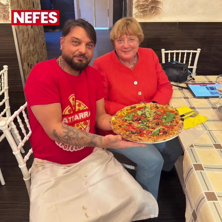 Angela Merkel sits alone in an Italian pizzeria