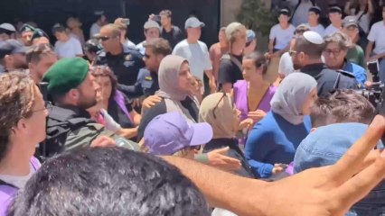 Palestinos son escoltados por activistas israelíes fuera de la Ciudad Vieja de Jerusalén durante la Marcha de la Bandera