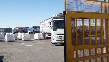 العمّال يفرغون المساعدات الإنسانية المخصصة لغزة عند معبر كرم أبو سالم