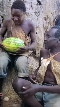 Hadzabe Tribe bushmen got this new fruit from neighbor tribe in exchange for some bush food, they are unsure how to eat it as it is not something common in their traditional lifestyle