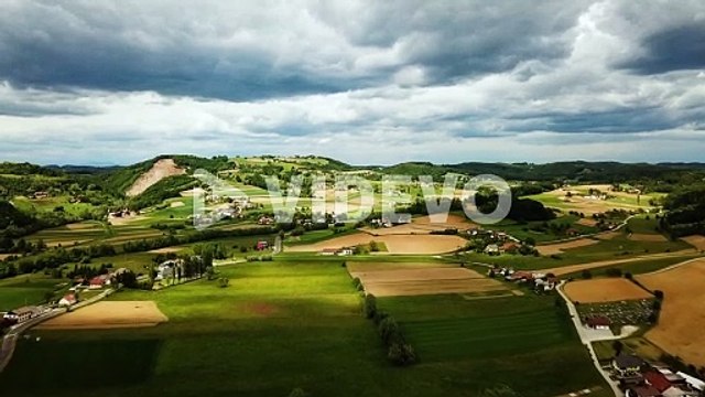 aerial landscape shot of slovenian countryside with hills houses and agricultural fields cloudy sky slovenia europe