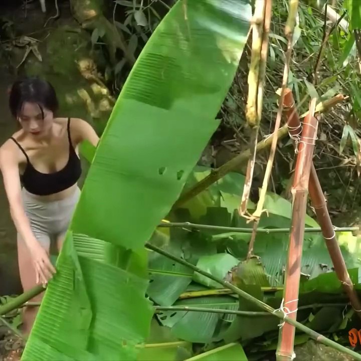 Solo girl camping making survival tent in the forest