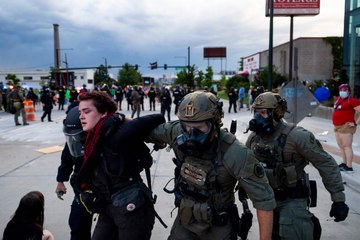 Police officers arrest protesters marching against immigration raids in Los Angeles