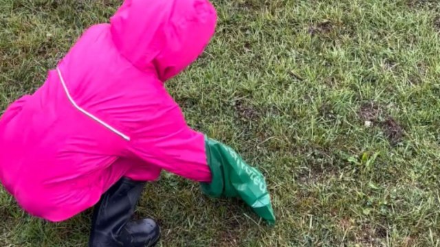 Little girl tries not to throw up while picking up her dog’s poo