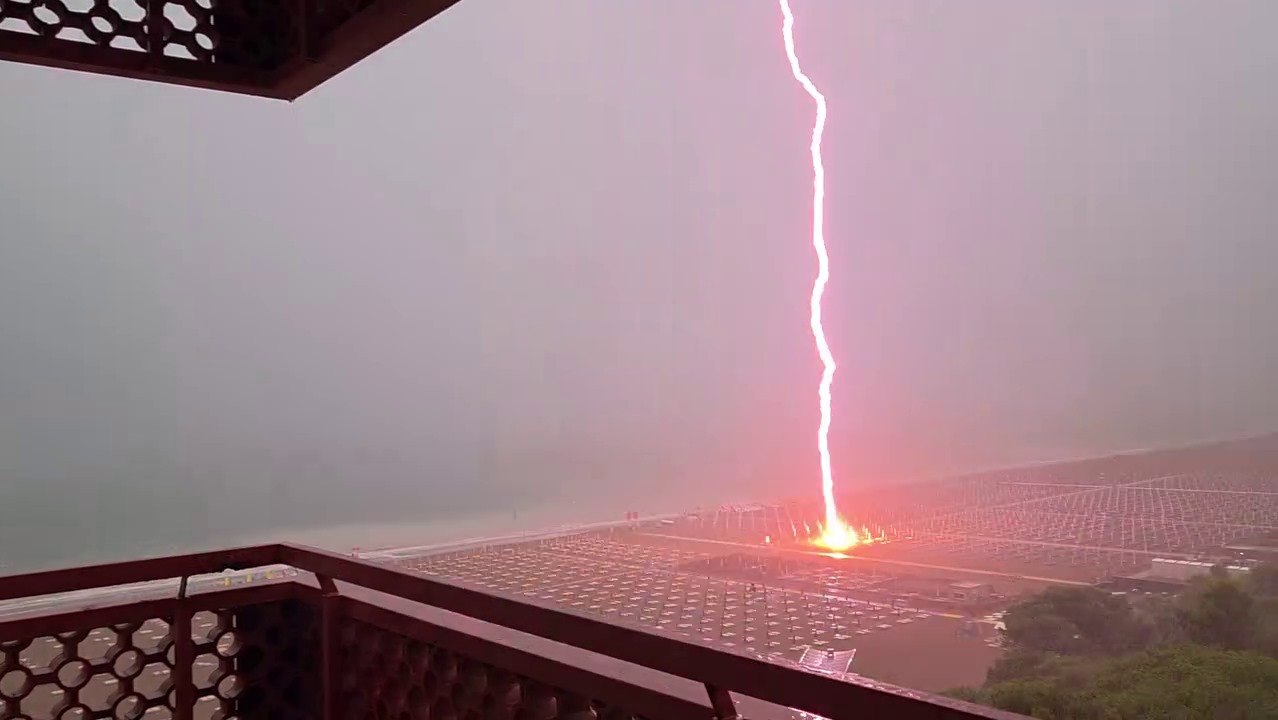 Fulmine cade in spiaggia a Lignano Sabbiadoro: il momento in cui squarcia il cielo e colpisce gli ombrelloni