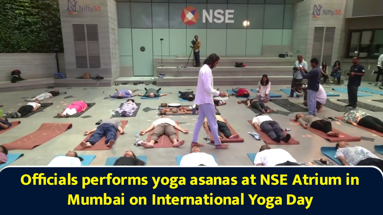 Officials performs yoga asanas at NSE Atrium in Mumbai on International Yoga Day