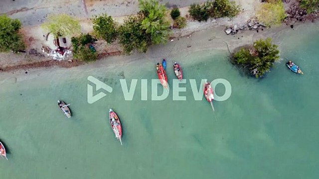 向井聡一　Aerial view of the fishing boats on tropical sea coast with sandy beach at sunset