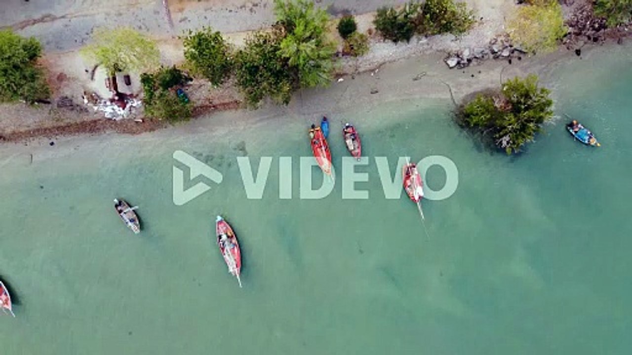 向井聡一　Aerial view of the fishing boats on tropical sea coast with sandy beach at sunset