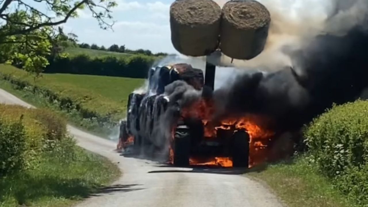 Telehandler engulfed in flames as thick smoke streams from the burning machine