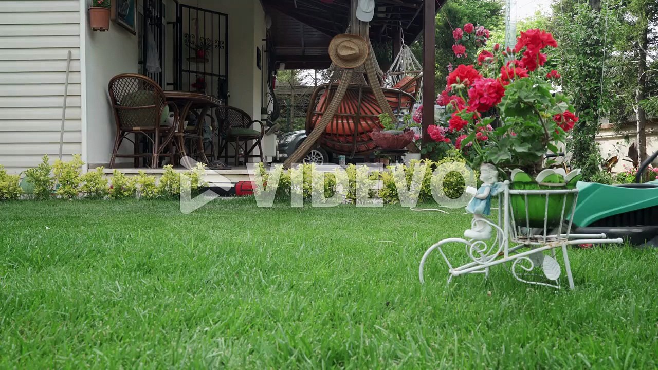 An old man mowing the grasses in his lawn with a electrical lawn mower
