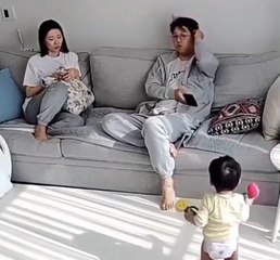 Parents watching their kid take his first steps.