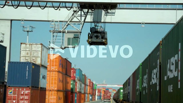 Operating cargo crane moves forward over ship containers at international port