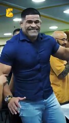 A bodybuilder displaying an angry attitude during an arm wrestling match.