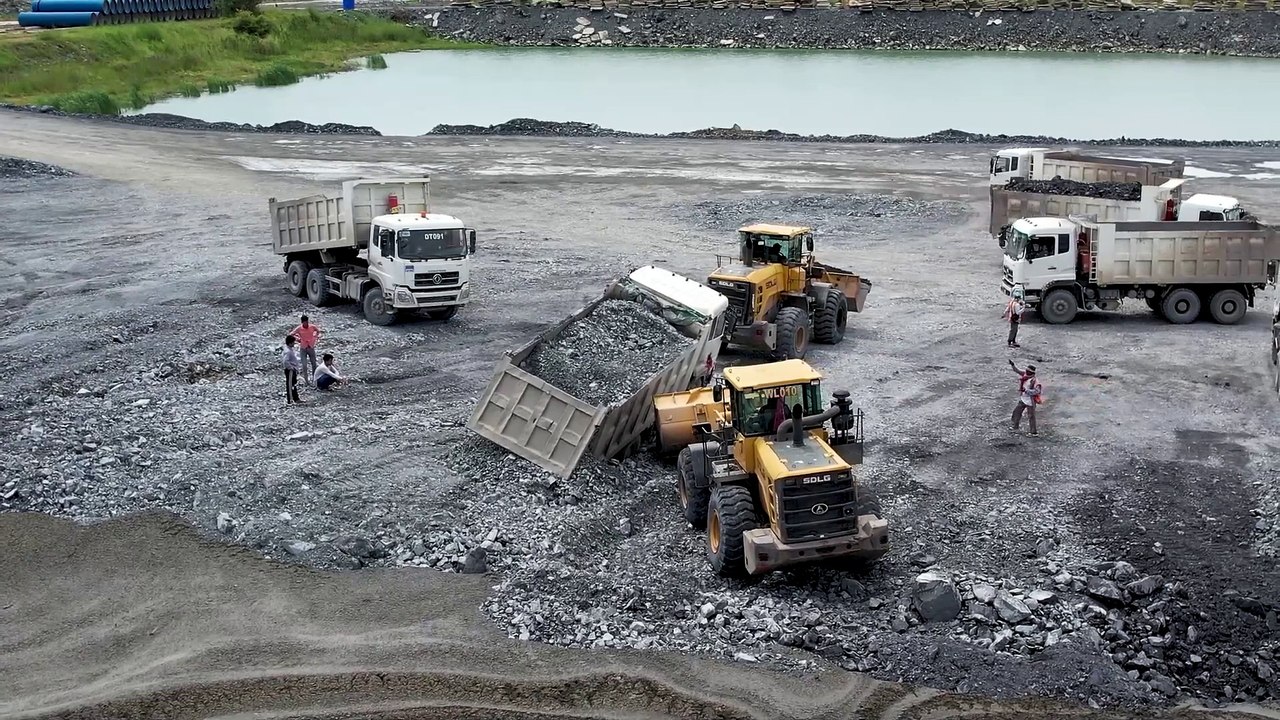 Incredible! Dump truck driving backward to unload rocks gets stuck in the mud-recovered by Excavator