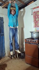 hombre se cuelga del techo de lámina para que no se lo lleve el viento