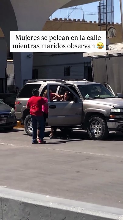 Mujeres se pelean en la calle mientras maridos observan