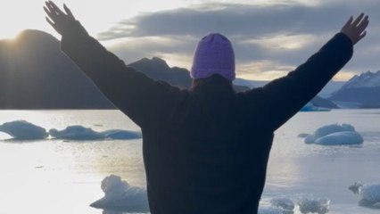 Girl poses for a photo on fragment of a glacier and falls down