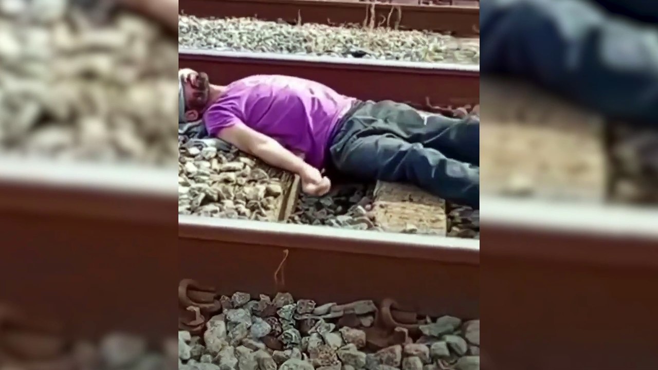 Homem deita nos trilhos e espera trem passar por cima
