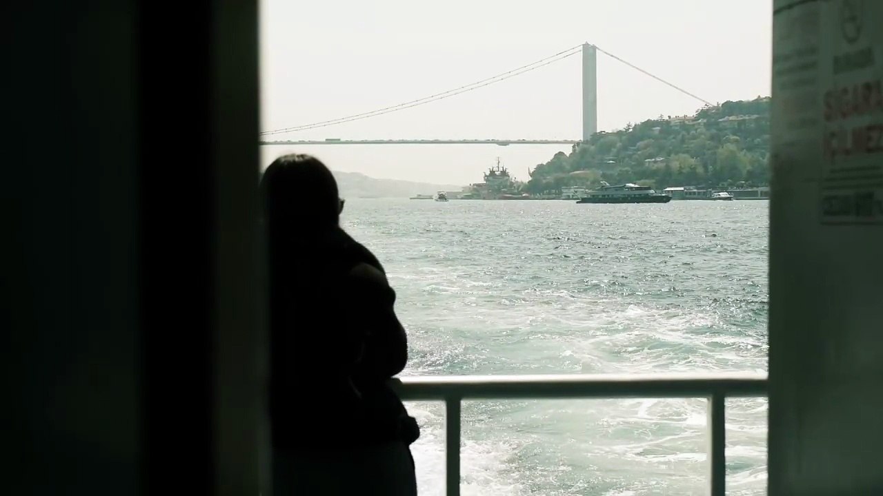 Silhouette on Ferry with Istanbul Bridge View