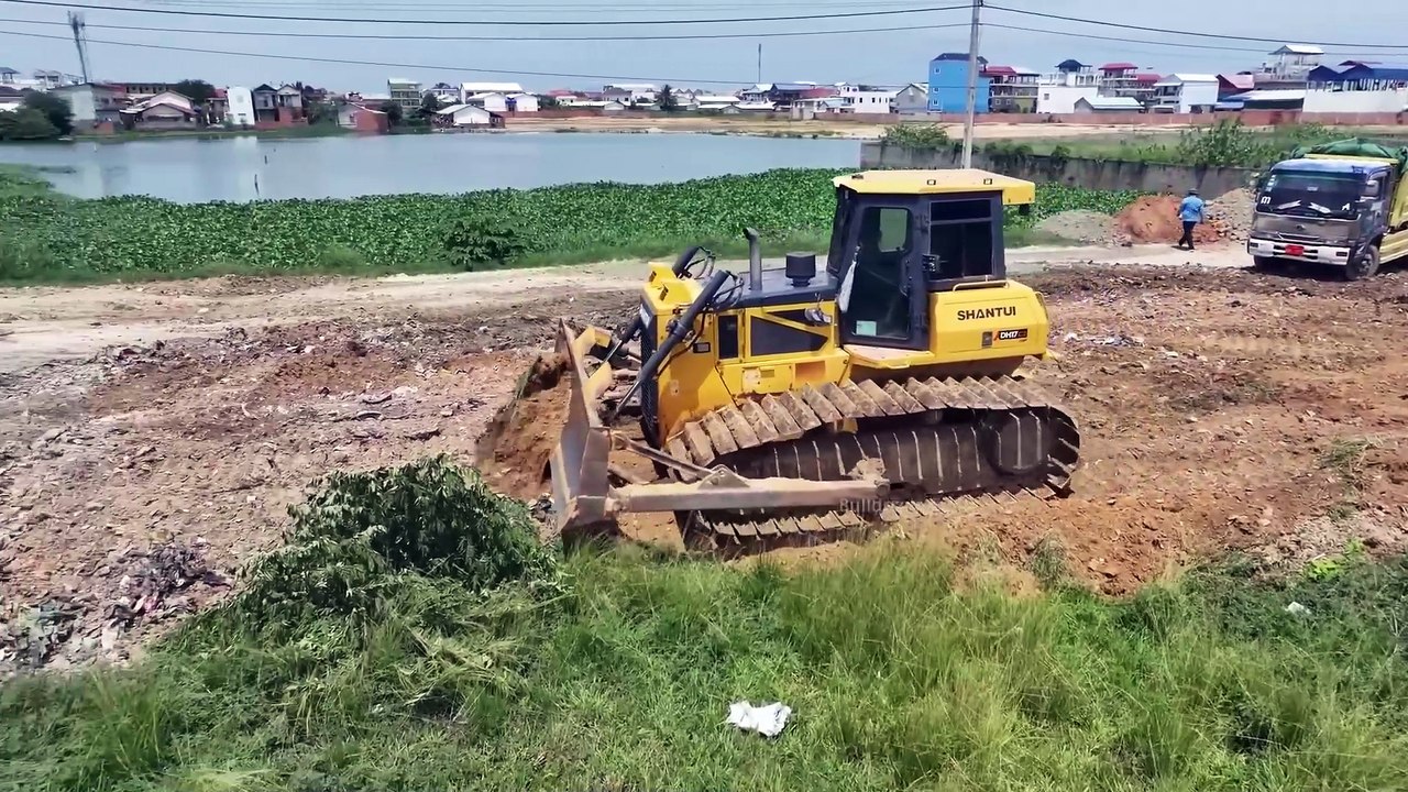 Wonderful!! skills big dozer shantui clearing garbage and pushing soil filling land with dump trucks