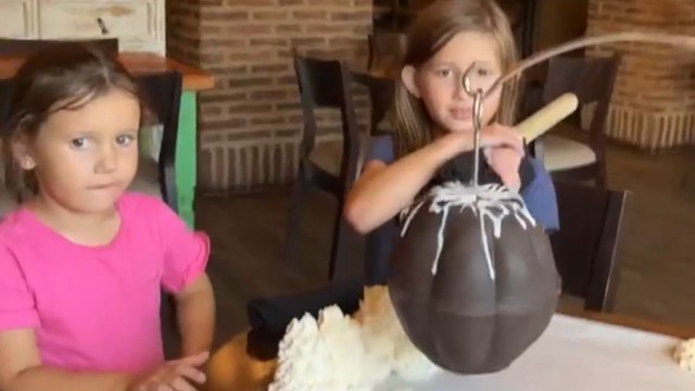Little girl tries to smash chocolate shell but accidentally hits another girl's head