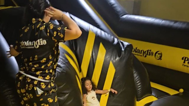 Little boy slides down and sends a little girl flying into ball pit
