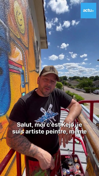 L'artiste Kejo réalise une fresque sur la façade d'une école