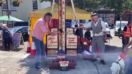 Having a go at the test-your-strength game (Will Goddard, Crediton Courier)