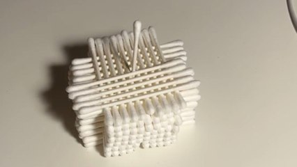 Boy creates a 3^3 cotton swab cube with steady hands