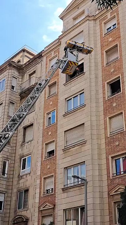Los bomberos de Barcelona extraen a una persona por la ventana para que reciba asistencia médica