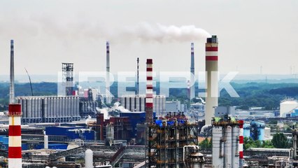 aerial drone view on oil terminal with smoke from chimneys in industrial facility for storage of oil and petrochemical