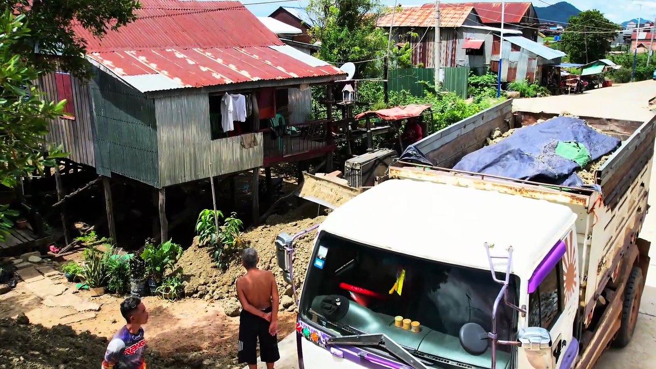 Drop the dirt in front of the home adjacent to the road to bury the pillars in front of the steps.