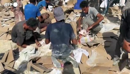 Gaza, i palestinesi raccolgono da terra il cibo in un centro di distribuzione
