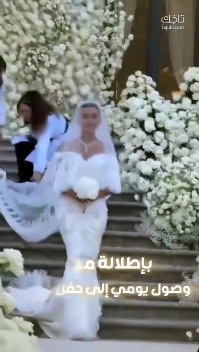 العروس يومي بيوتي بتسريحة الكعكة المصقولة والمكياج النيود الوردي في زفافها