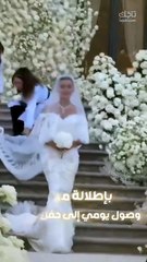 العروس يومي بيوتي بتسريحة الكعكة المصقولة والمكياج النيود الوردي في زفافها