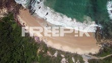 bartletts beach with vegetated bluffs and waves splashing. bonny hills, new south wales, australia. aerial topdown shot