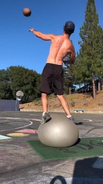 Man Hoops Rugby Ball While Balancing on Stability Ball