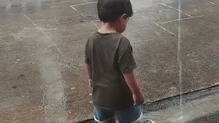 Child chases flip-flops after water current sweeps them away