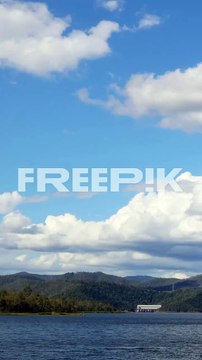 clouds drift over a tranquil lake and hills