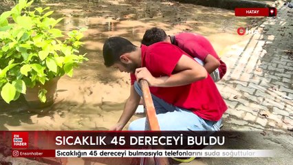 Hatay'da sıcaklığın 45 dereceyi bulmasıyla telefonlarını suda soğuttular